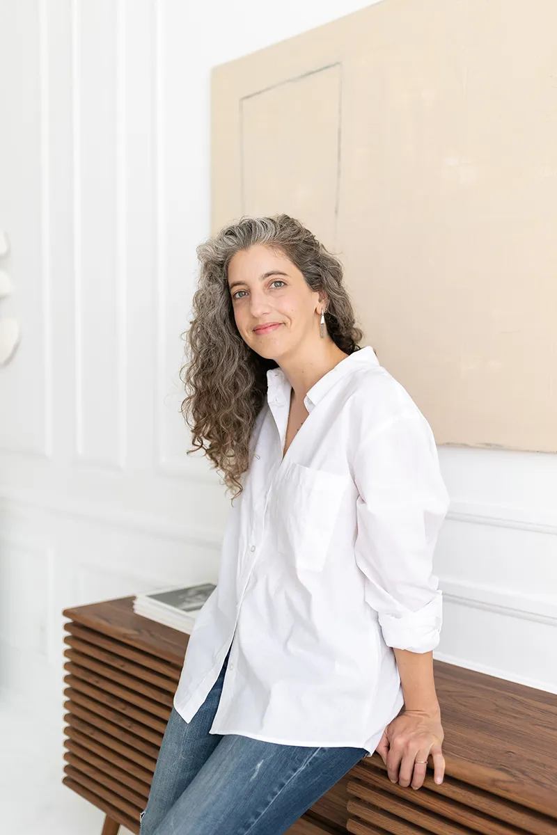 Emily Sadowski in white shirt, leaning on a console